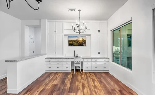 We transformed this blank wall into a custom workstation featuring floor-to-ceiling cabinetry from Wellborn Cabinet, Inc., maximizing storage and functionality.